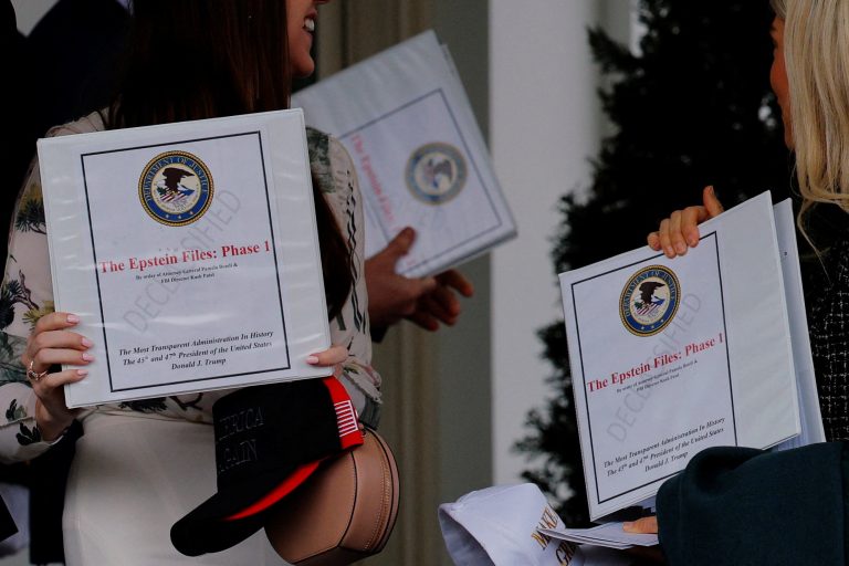 FILE PHOTO: People walk out of the West Wing and show "The Epstein Files: Phase 1" binders, in Washington, D.C.