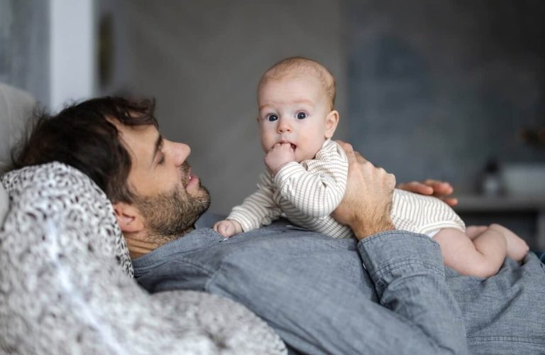 Father on paternity leave looking after his infant son at home