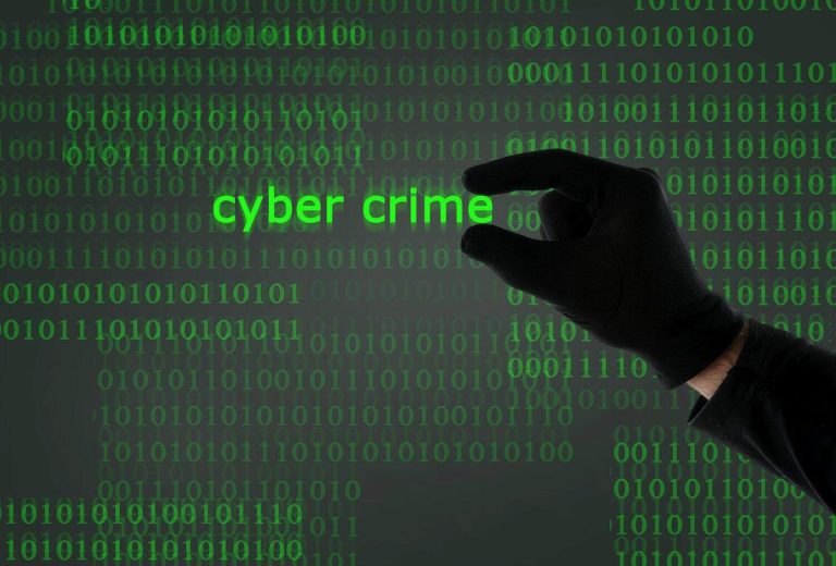 hacker hand holding cyber crime text from computer screen