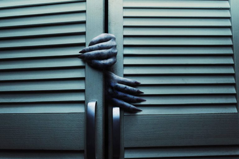 Blue toned cupboard doors with scary female monster hands.