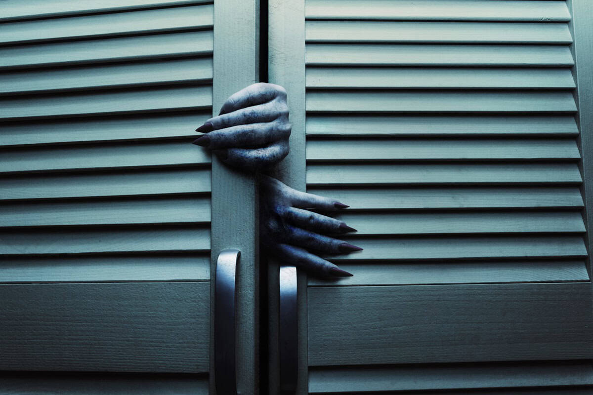 Blue toned cupboard doors with scary female monster hands.