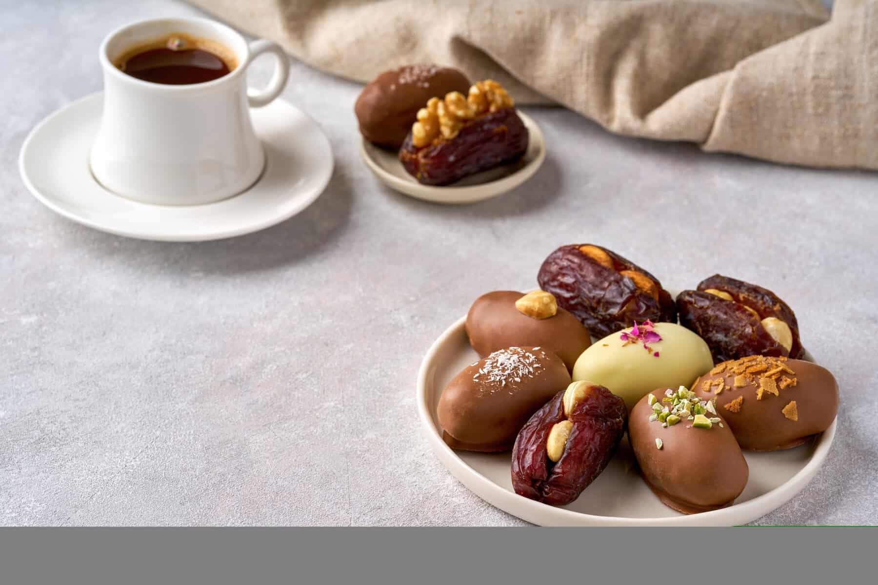 Dates fruit filled with nuts and glazed in chocolate. Closeup with copy space
