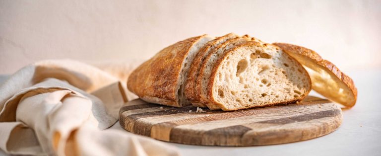 Freshly Baked Sourdough Bread Sliced on a Wooden Cutting Board