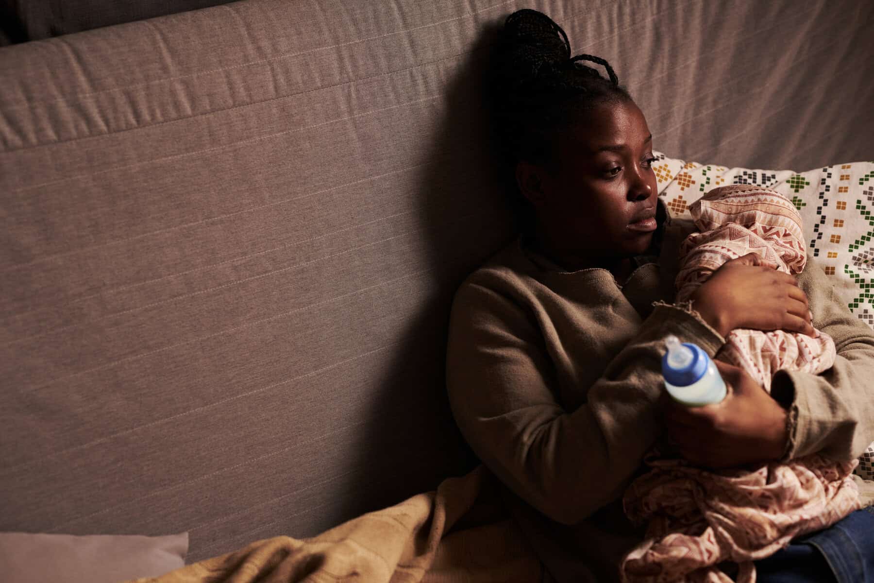 Miserable young woman holding baby