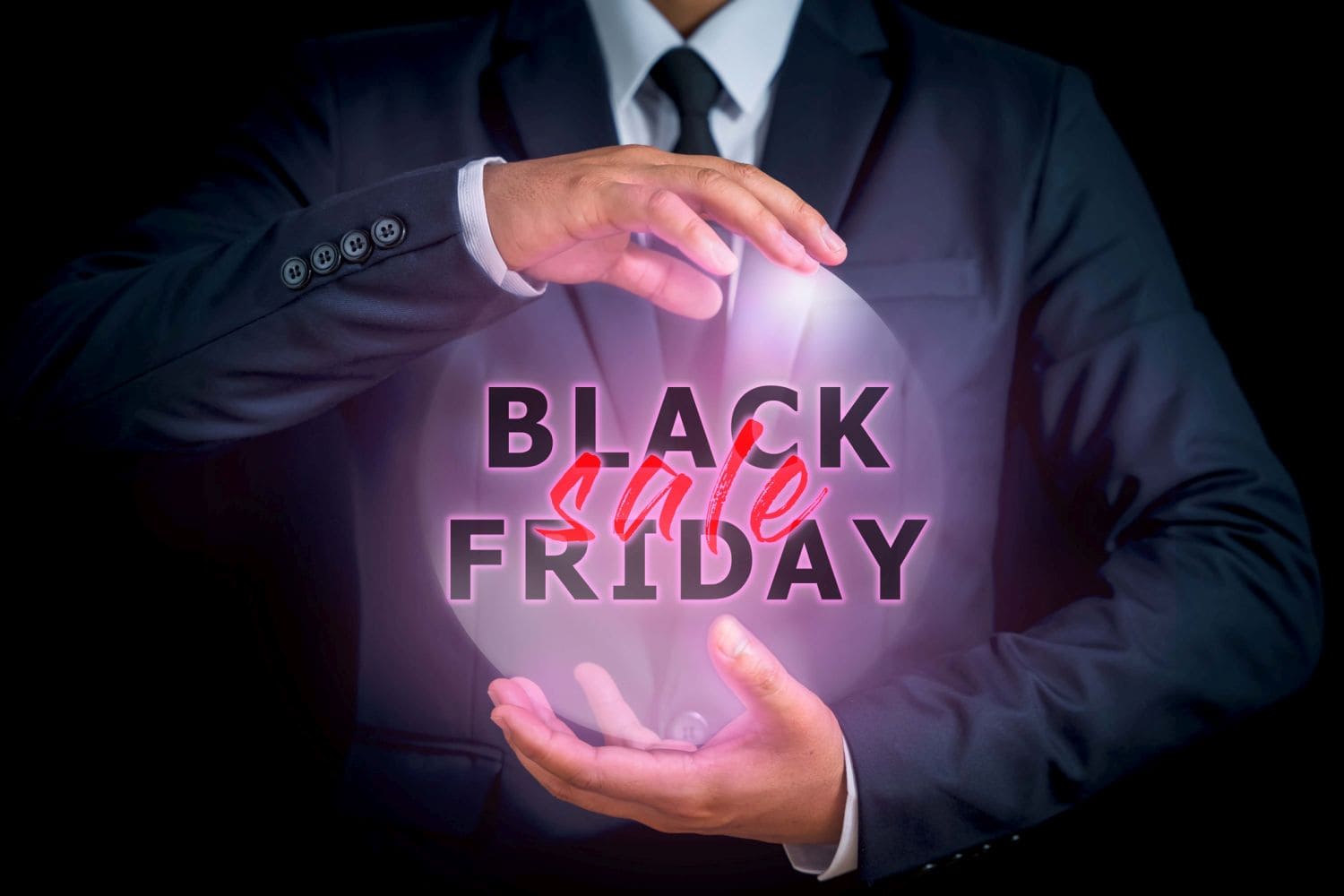 The man in the jacket suit, center between his hands has the words BLACK FRIDAY in black letters and SALES in red letters to remind you how prepared you are for the season. that is coming soon