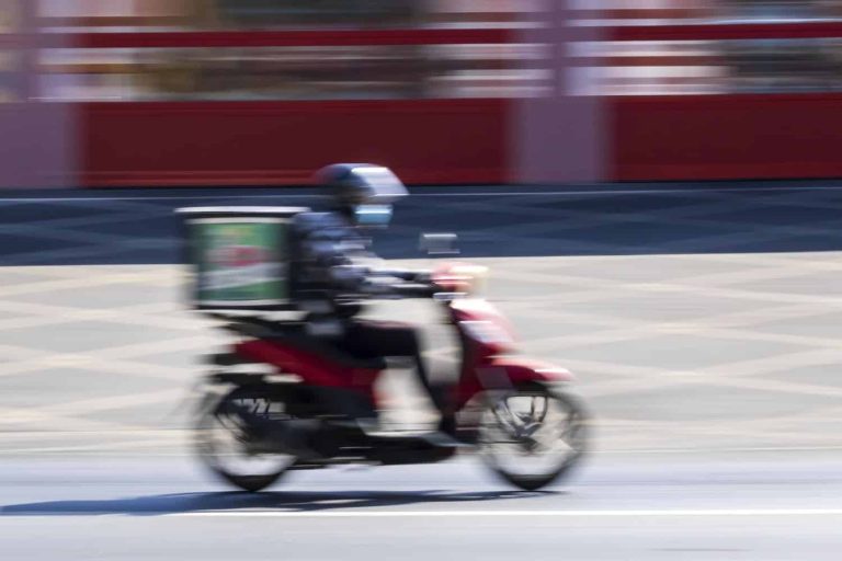 Delivery man on motorbike in motion
