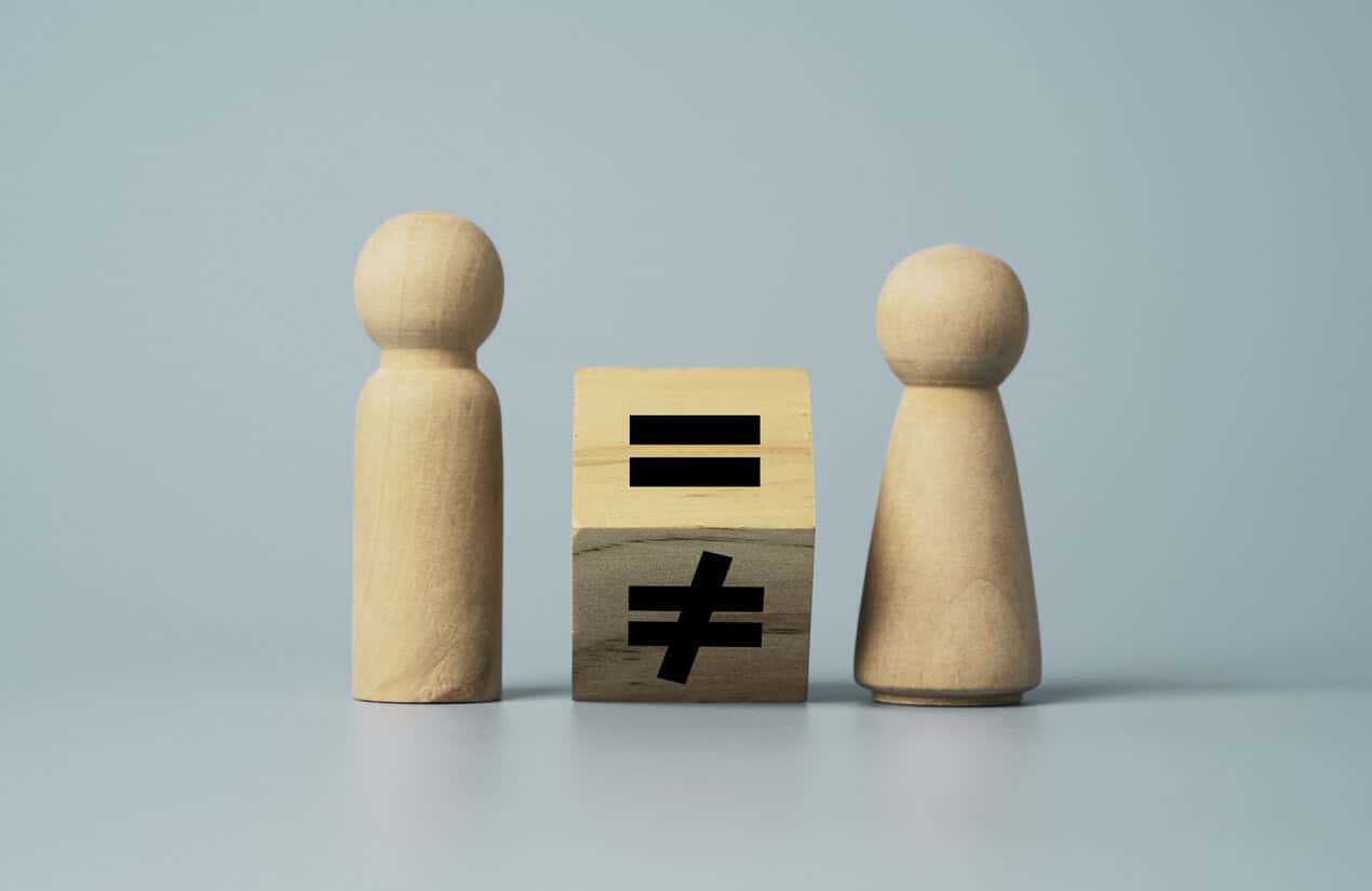 Flipping of unequal to equal sign between man and woman wooden figure. Human and business right concept.