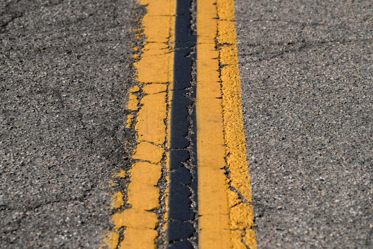 Cracked Road with Yellow Line