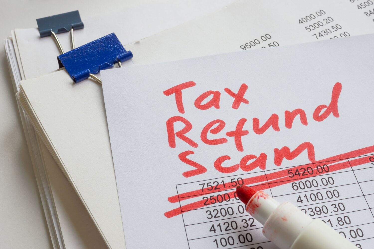 Stack of papers with the label tax refund scam.