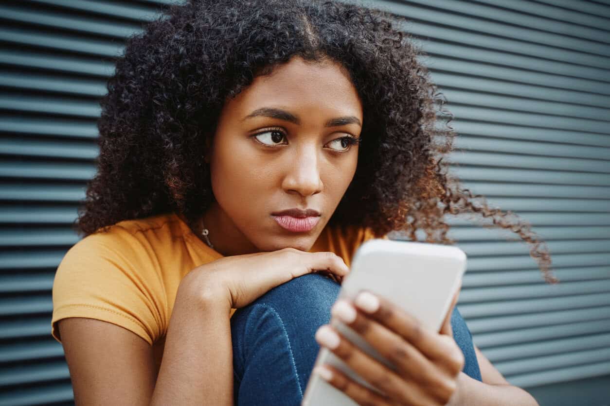 Portrait of one lonely black girl using cellphone