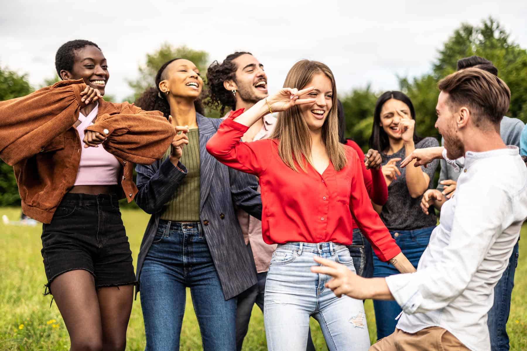 Multiracial group of friends dancing together on the park - Multiethnic friends having fun in the university campus