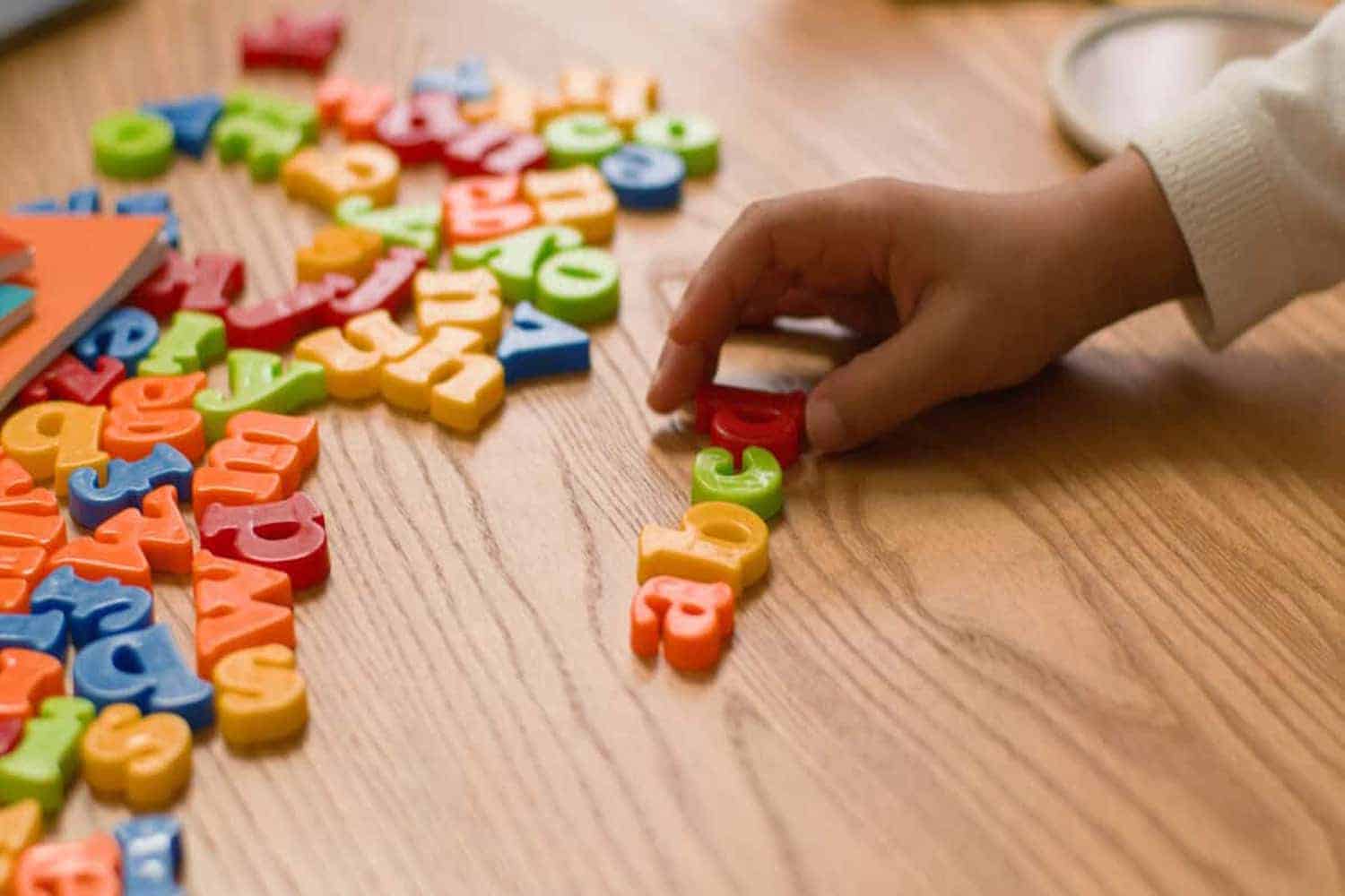 Hands lay out letters alphabet learning study children teach preschool educational kindergarten english language school text lettering development interactive literacy creativity toy colourful toddler