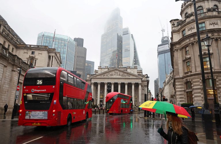 FILE PHOTO: Commuters walk in City of London financial district in London