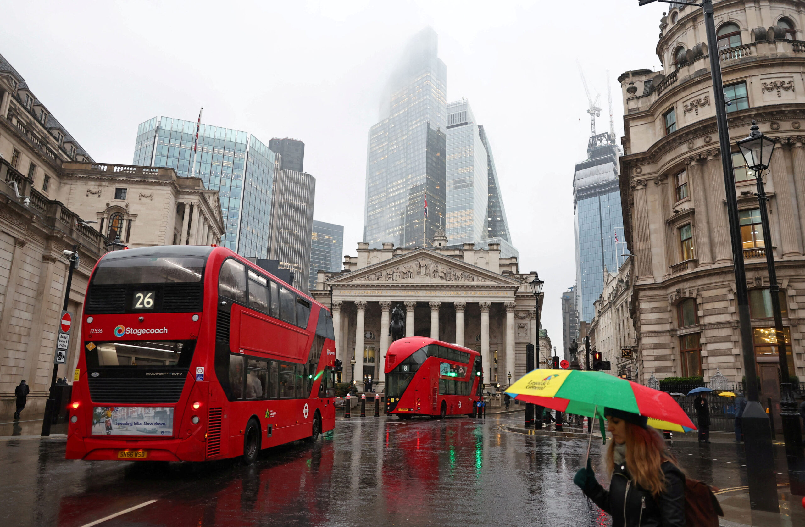 FILE PHOTO: Commuters walk in City of London financial district in London
