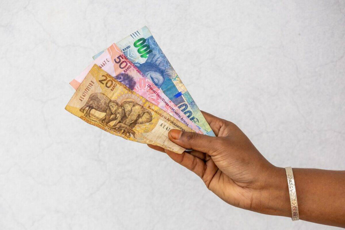 Female hand holding South African Rand banknotes R20 R50 R100. South Africa money financial concept.