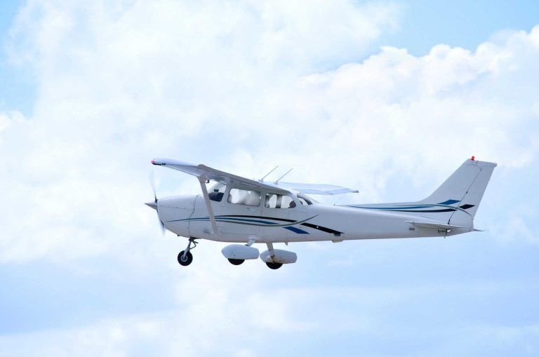 Small private single engine airplane in flight with clouds