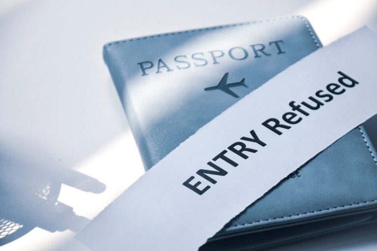 Torn paper with the inscription Entry refused on Passport. Denied entry or entry ban to a country concept, selective focus.