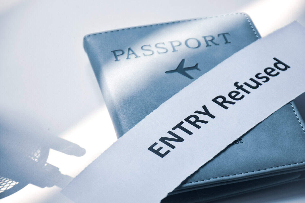 Torn paper with the inscription Entry refused on Passport. Denied entry or entry ban to a country concept, selective focus.