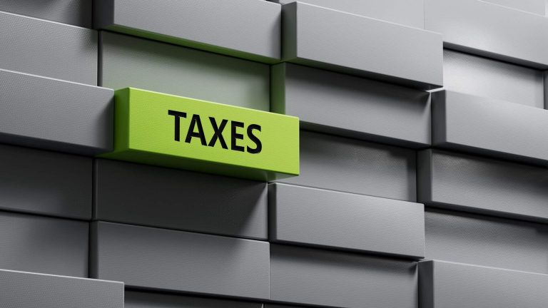metal blocks with TAXES business word.close up of metal blocks,Business Concept.3D rendering on green background.