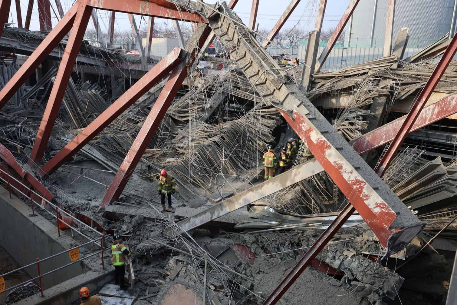 Rescuers work at the site of a collapsed building that was under construction