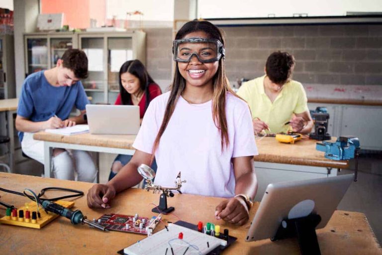 Looking at camera portrait of a young student wearing safety goggles in technical vocational training college, the lesson in High School. Education and technology concept.