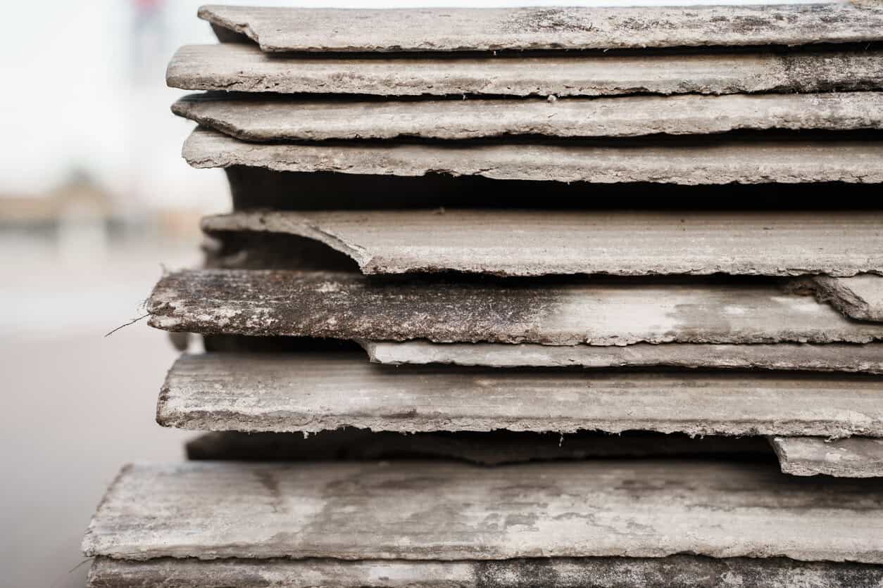 Old and very dangerous asbestos roof. Asbestos dust in the environment. Asbestos removal