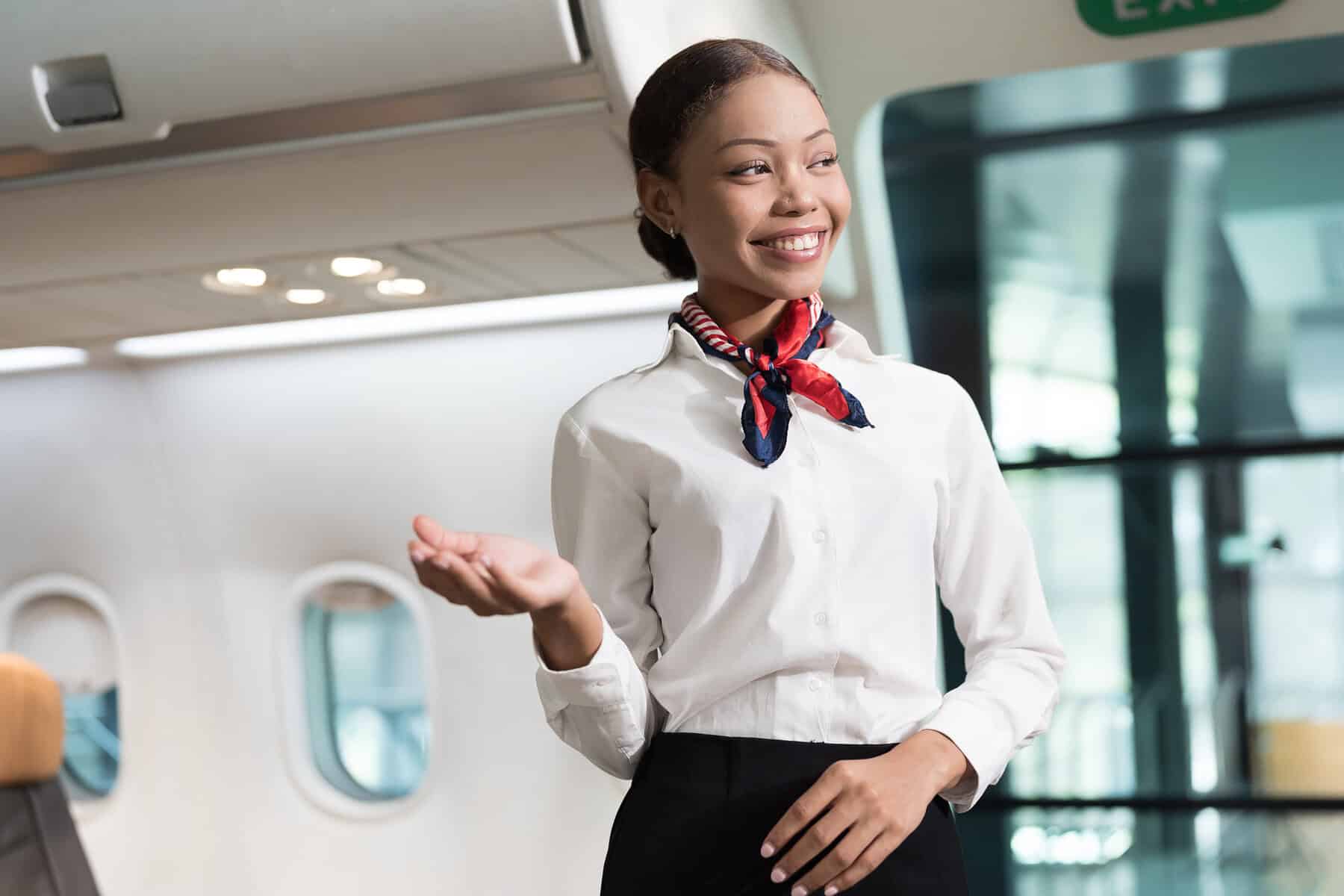 Black woman, Cabin crew or air hostess working in airplane. Female airline service agent working on plane with travel services smiling