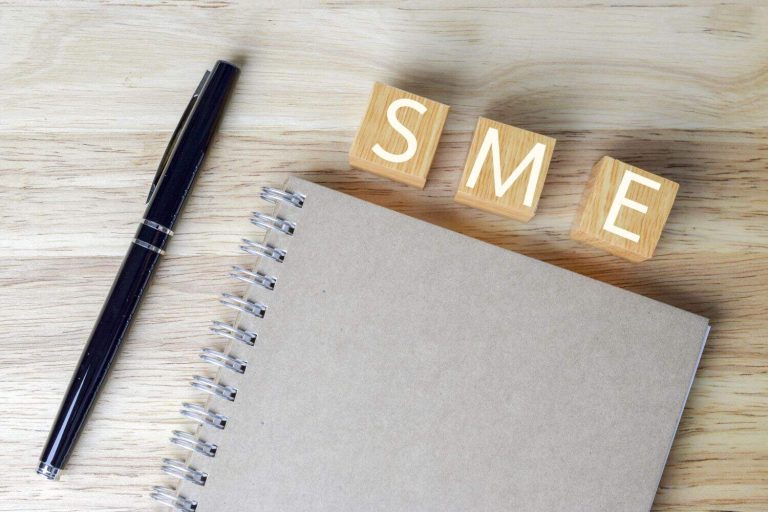 Wood blocks with word SME on wooden table - Small and Medium Enterprise concept