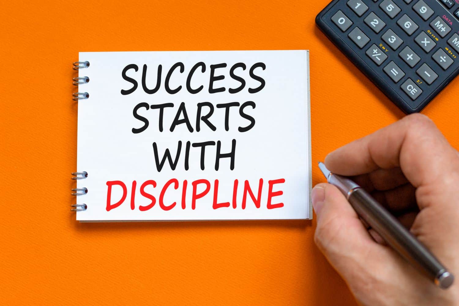 Success starts with discipline symbol. Concept words Success starts with discipline on beautiful white note. Beautiful orange background. Business success starts with discipline concept. Copy space