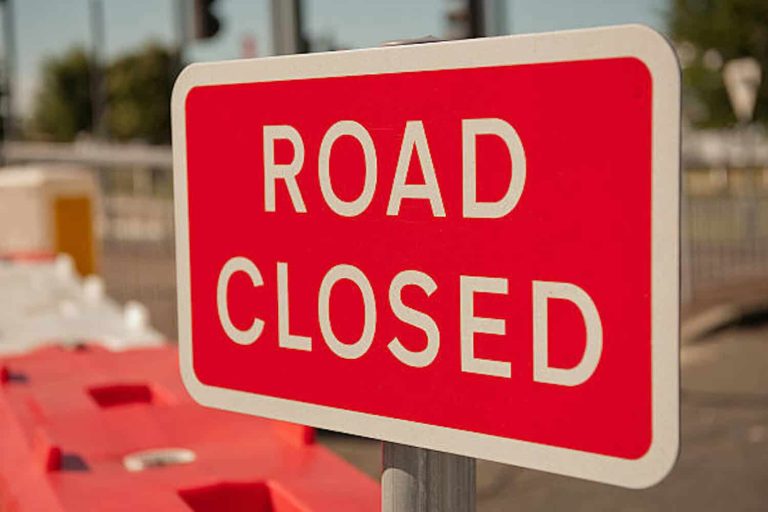 Close up of a red & white ROAD CLOSED sign.