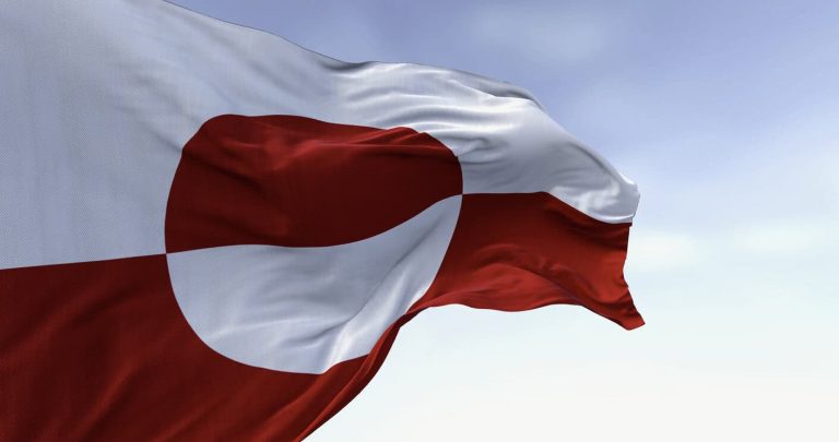 The flag of Greenland waving in the wind on a clear day.