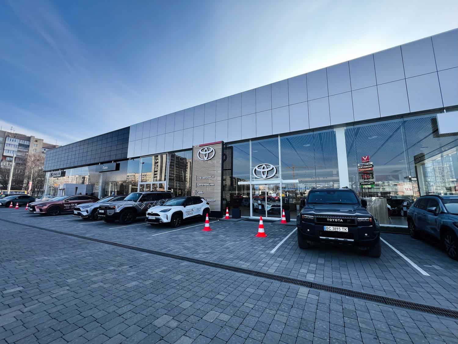 Exterior view of modern Toyota car dealership with parked cars in urban setting