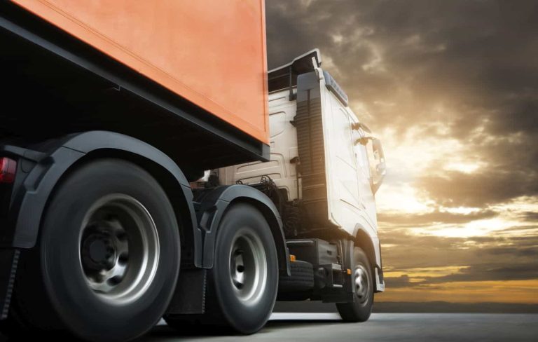 Semi truck trailer driving on road at sunset sky. Cargo freight truck, Logistics and transportation.