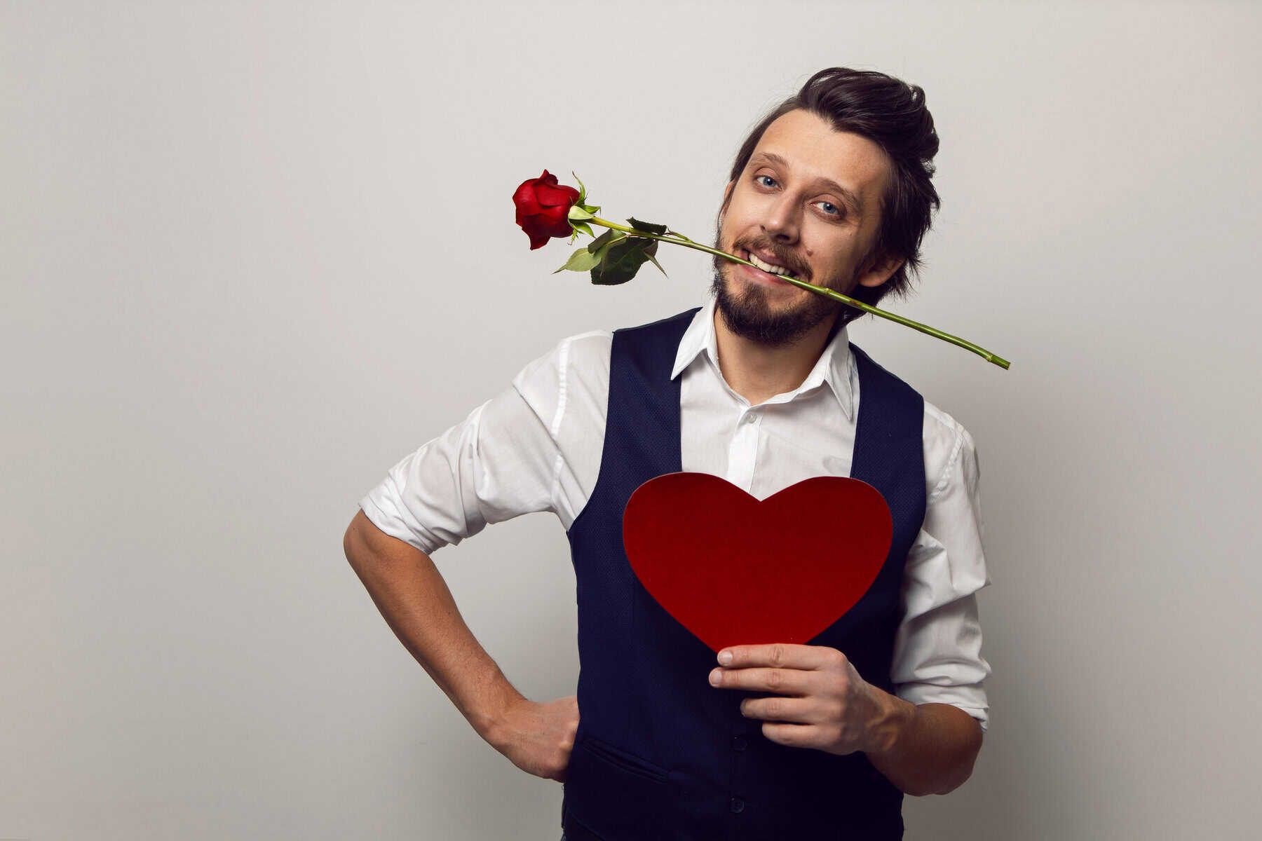 valentine's day businessman man with glasses and beard holding a red heart in the studio on a white background at the cardiologist