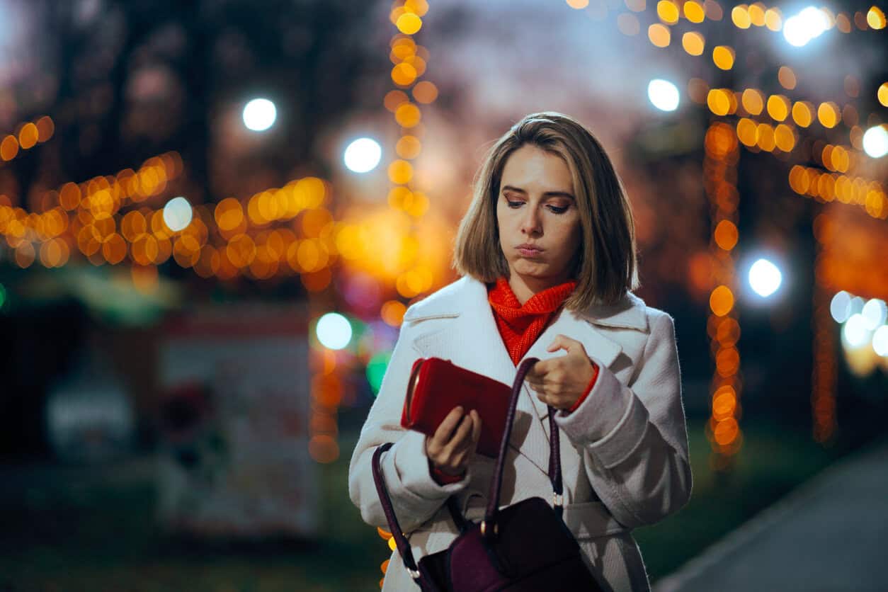 Woman Holding her Wallet Being Worried About Christmas Overspending