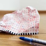 Lottery ticket on the floor.  Symbolic image of losing at gambling and wasting money.