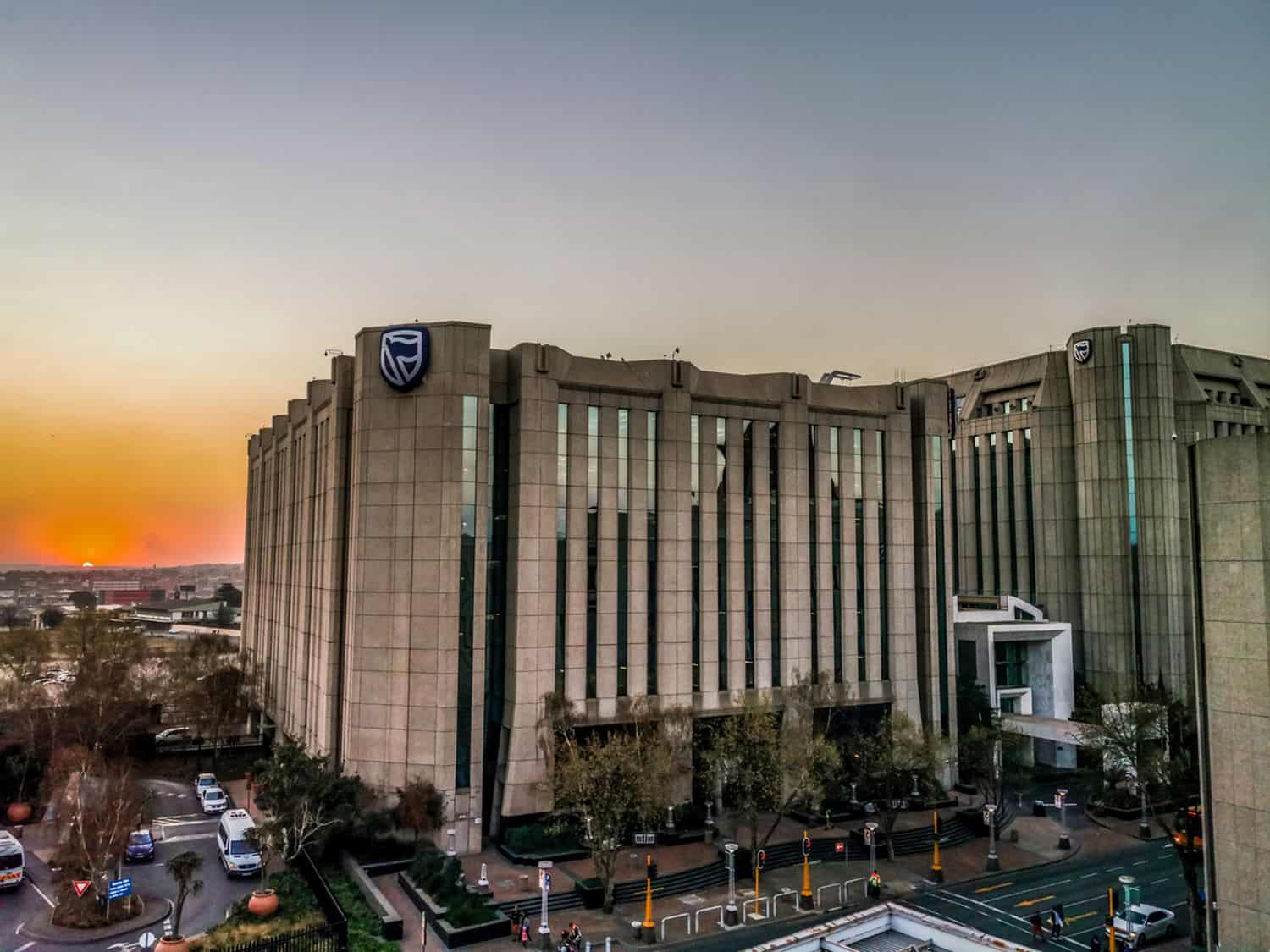 Beautiful and tall Standard bank buildings in Simmonds street Selby Johannesburg CBD area under a cloudy and sunset sky
