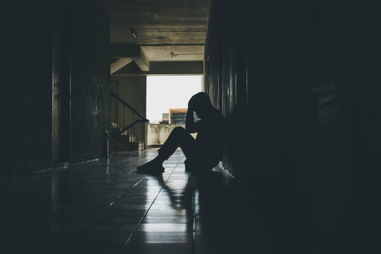Dramatic, Silhouette of Sad Depressed man sitting head in hands on the floor. Sad man, Cry, drama, lonely and unhappy concept.