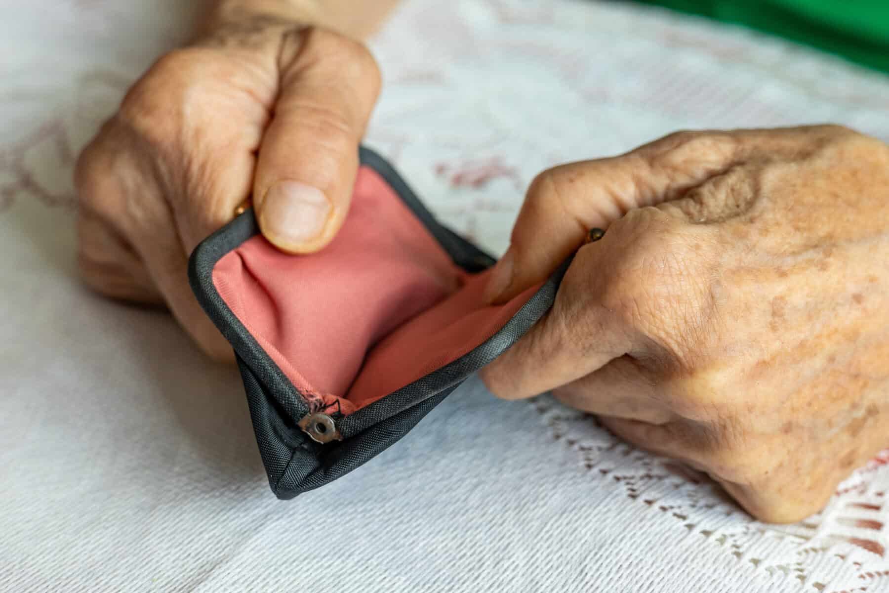 The senior is holding an empty wallet. Financial and business concept. Support for the elderly and lonely. Close up