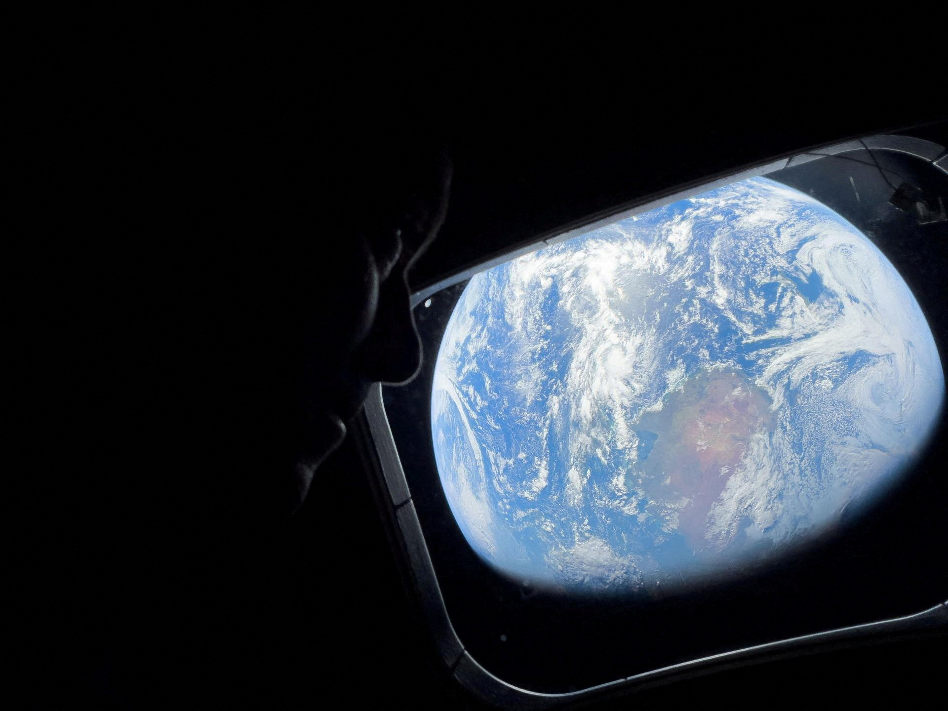 NASA astronaut and Artemis II Commander Reid Wiseman peers out of one of the Orion spacecraft's main cabin windows