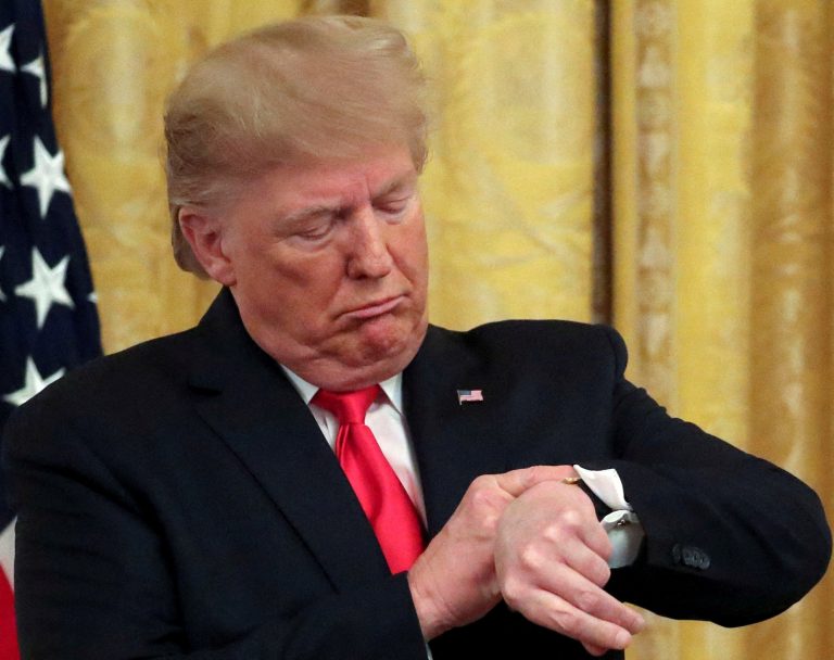 FILE PHOTO: U.S. President Trump checks his watch during an event in the East Room of the White House in Washington, D.C.