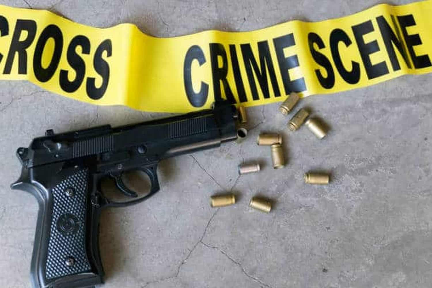 Crime scene concept with bullet casings and black gun