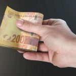 Hand Passing Wad Of Cash