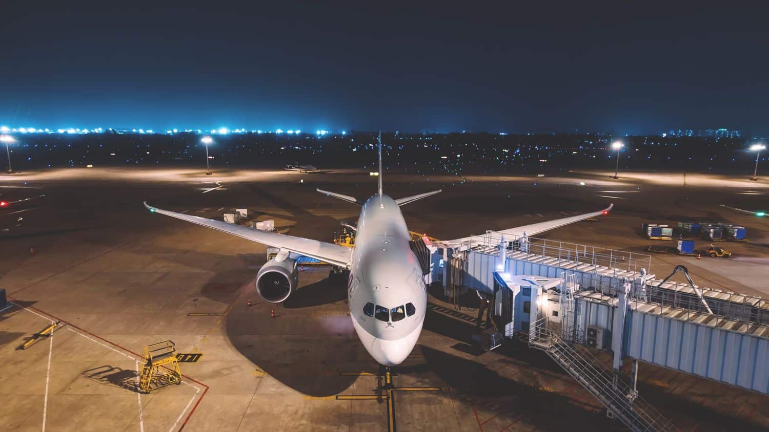 passenger commercial airplane parked at airport gate at night