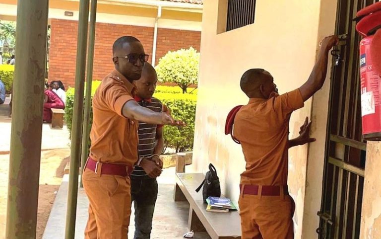 202604Paul-Mugerwa-being-led-by-prison-officers