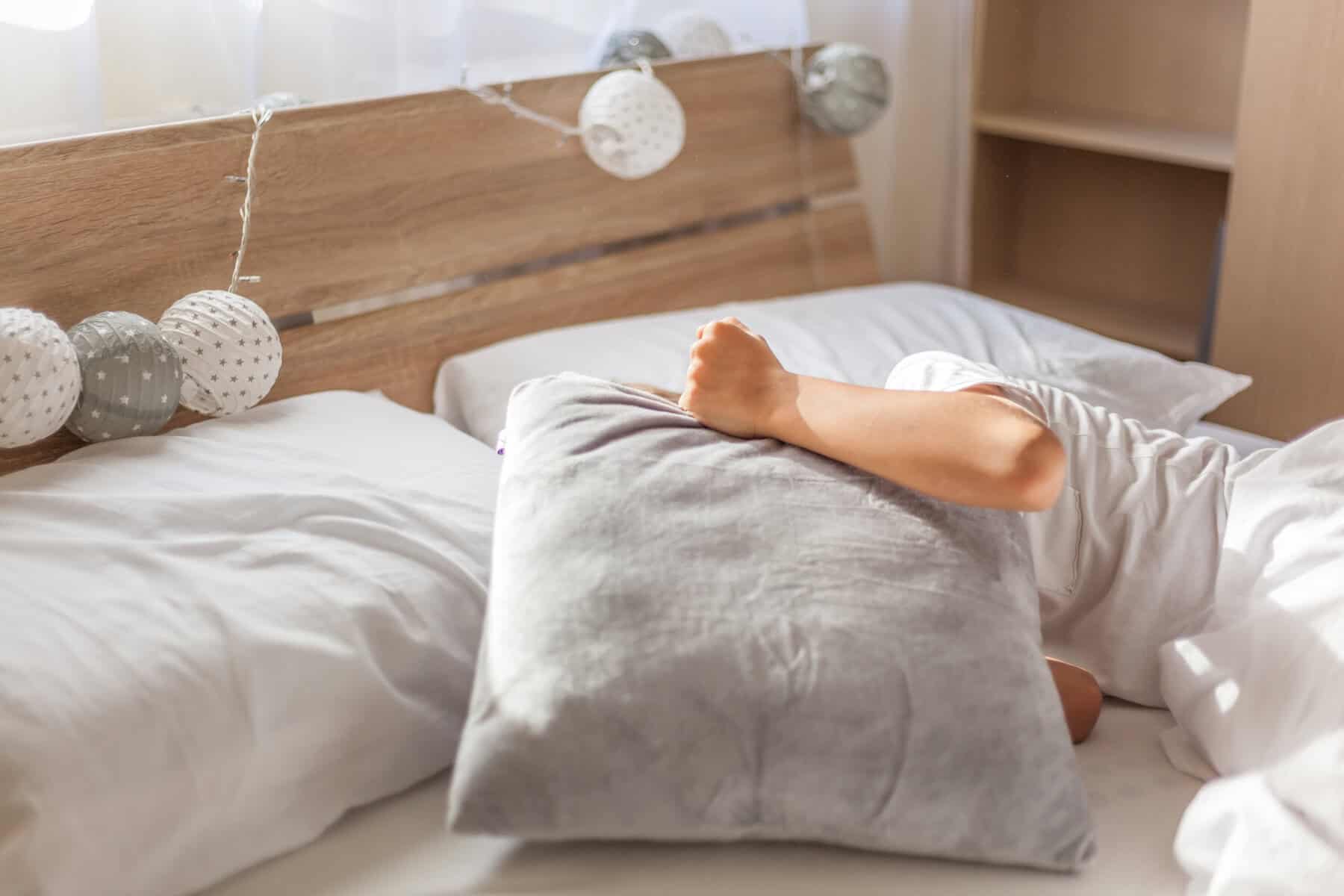 High Angle View Of Cheerful Boy Lying On Bed At Home