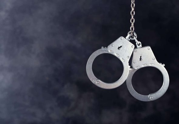 Handcuffs hanging on dark