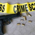 Crime scene concept with bullet casings and black gun