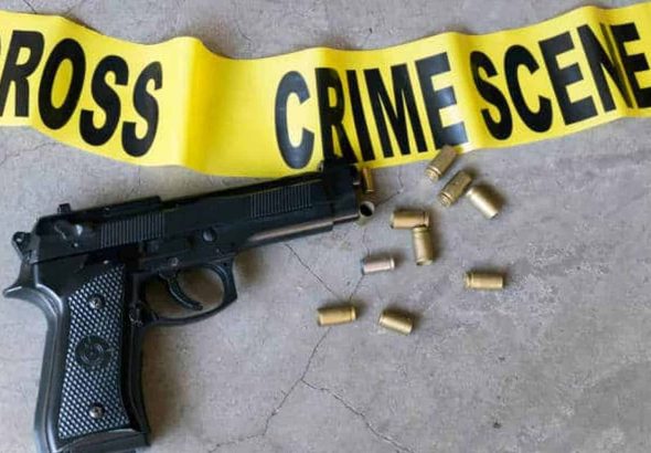 Crime scene concept with bullet casings and black gun