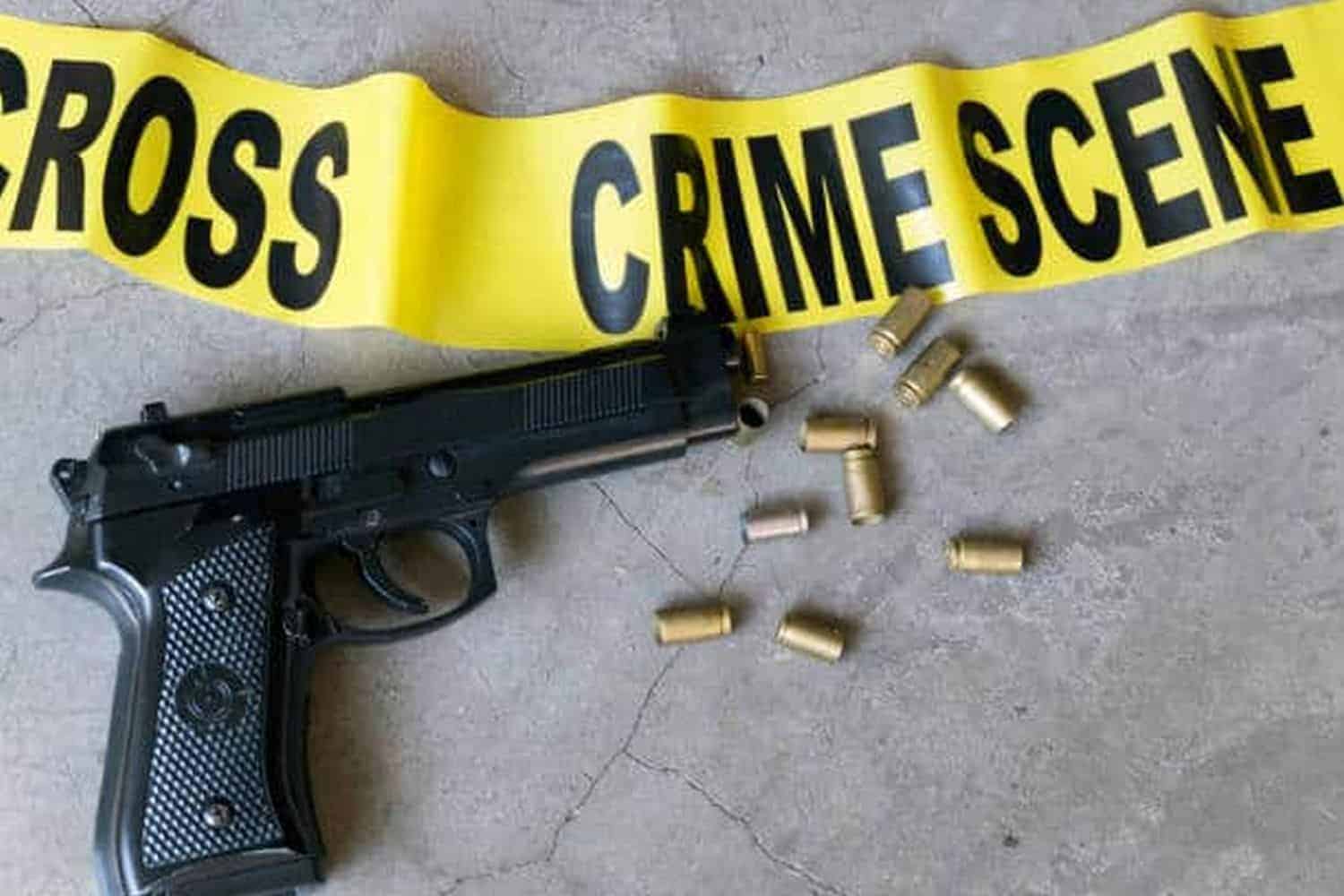 Crime scene concept with bullet casings and black gun